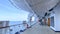 A group of passengers lounging in chairs under the life rafts on the deck of a cruise ship