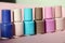 Group of pastel colored nail polishes isolated on pink bacground