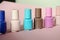 Group of pastel colored nail polishes isolated on pink bacground