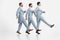 Group of pensive men wearing old-fashioned clothes standing in a row and marching over white background. Gentlemen