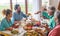 Group of people of all ages eating together at home food - happy adults and seniors togetherness - have lunch indoors