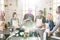 Group of people in aprons looking at display of tablet held by cooking coach