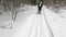 A group of people with big backpacks are skiing through a beautiful winter forest. First-person view.