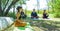 Group of people doing yoga exercise in the park, womans relaxing in the park