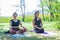 Group of people doing yoga exercise in the park, womans relaxing in the park