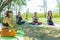 Group of people doing yoga exercise in the park, womans relaxing in the park