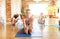 group of people doing yoga forward bend at studio