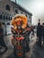 Group of people dressed in autumnal attire stroll down a street during the Carnival of Venice