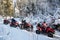 Group of people driving off-road four-wheelers ATV bikes in winter forest