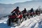 Group of people driving off-road quad bikes on snow in winter