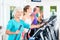 Group of people on elliptical trainer exercising in gym