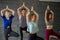 Group of people engaging in his healthy hobby-practicing yoga, Tree Pose.