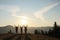 Group of people enjoying sunrise in mountains, back view. Space for text