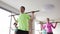 Group of people exercising with bars in gym