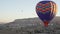 Group of people flying in balloon over rocks