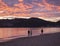 Group of people flying a drone during beautiful blue pink orange clouds sunset on Agios Georgios Pagon beach at Corfu