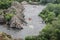 Group of people with guide whitewater rafting and rowing on river