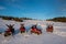 Group of people with hands up on four-wheelers ATV bikes in the the mountains in winter evening