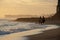 Group of people having horse riding adventure on sand sea beach