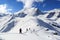 Group of people hiking on snowshoes and mountain snow panorama with blue sky in Stubai Alps
