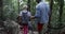 Group Of People Hiking Trail Forest Path Helping Each Other, Friends Tourists With Backpacks Trekking Together Back Rear