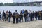 Group of people, journalists and cameramen, standing on a river beach, press-conference
