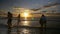 Group of people jumping dancing and having fun in the water on beach at sunset - slow motion