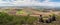 Group of people looking at rural landscape with villages, fields and mountains in background