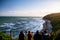 Group of people are looking at the view of the ocean at sunset