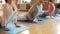 Group of people making yoga exercises in gym