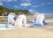Group of people making yoga exercises over beach