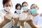 Group of people with medical mask to prevent infection from spreading of Covid-19,asian family raised a fists and prepare for the