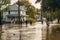 Group of People Navigate Flooded Street Near Architectural Building