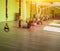 A group of people picks up a TRX hinge in the modern gym with a trainer and do the reverse twisting exercise, blurred, copy space