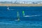 The group of people plays windsurfing with cargo port in the background, at Kyeemagh Beach Baths.