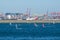 The group of people plays windsurfing with Qantas Airline plane on the runway and cargo port in the background, at Kyeemagh Beach.