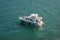 Group of people on pleasure boat hold up â€œHAVE FUNâ€ sign and wave to the departing Cruise ships