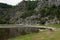 Group of people relax on shore during canoe rafting on river. Tourists rafting down or floating on mountain river