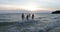 Group Of People Running In Sea Holding Hands Back Rear View Of Cheerful Friends Together On Beach At Sunset Having Fun