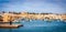 A group of people sitting in a harbor next to a body of water in Malta