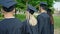 Group of people students graduated standing together backwards at university campus