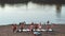 A group of people with supboards on a beach near a body of water