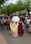 A group of people visiting the stalls at the Saint Isidro fair. 2 women with their backs turned dressed in traditional Madrid