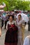 A group of people visiting the stalls at the Saint Isidro fair. 2 women with their backs turned dressed in traditional Madrid