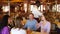 Group of people waiting for food in restaurant, waiter serving table