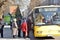 Group of people waiting in queue to enter local city bus on bus stop station