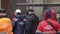 Group of people walk around construction area on snowing winter day.