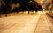 A group of people walking along the sidewalk promenade long exposure at night