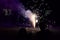 Group of people watching a dazzling display of fireworks light up the night sky