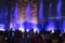 A group of people watching a light show and a fountain